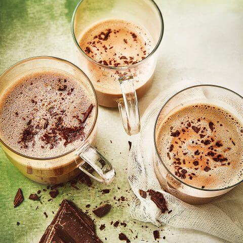 three glass mugs full of rich and creamy vegan hot chocolate