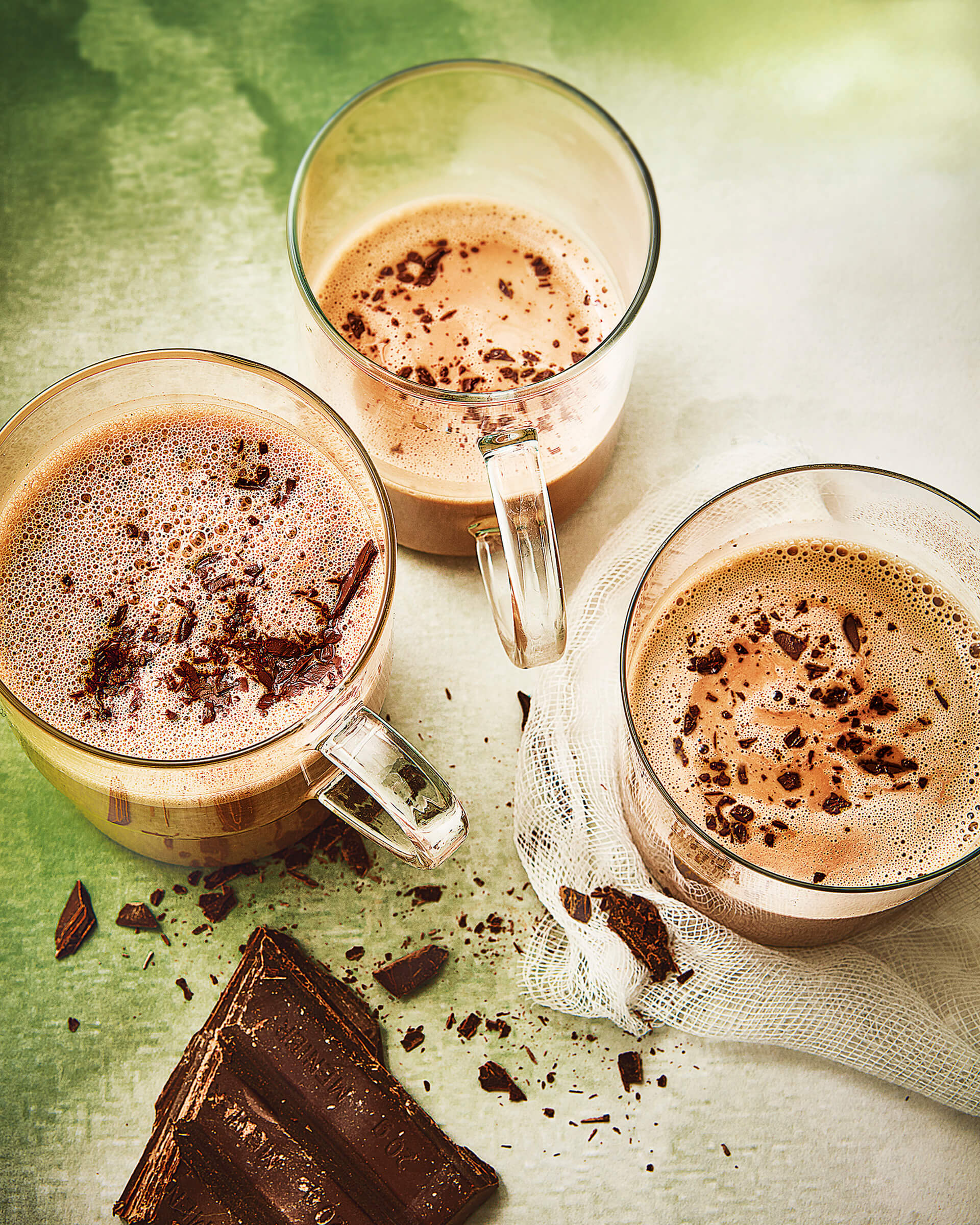 three glass mugs full of rich and creamy vegan hot chocolate
