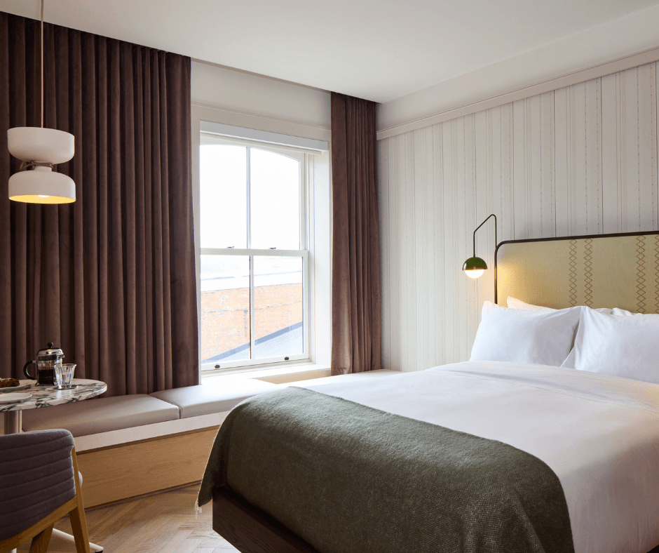 Bed with white sheets and grey throw blanket