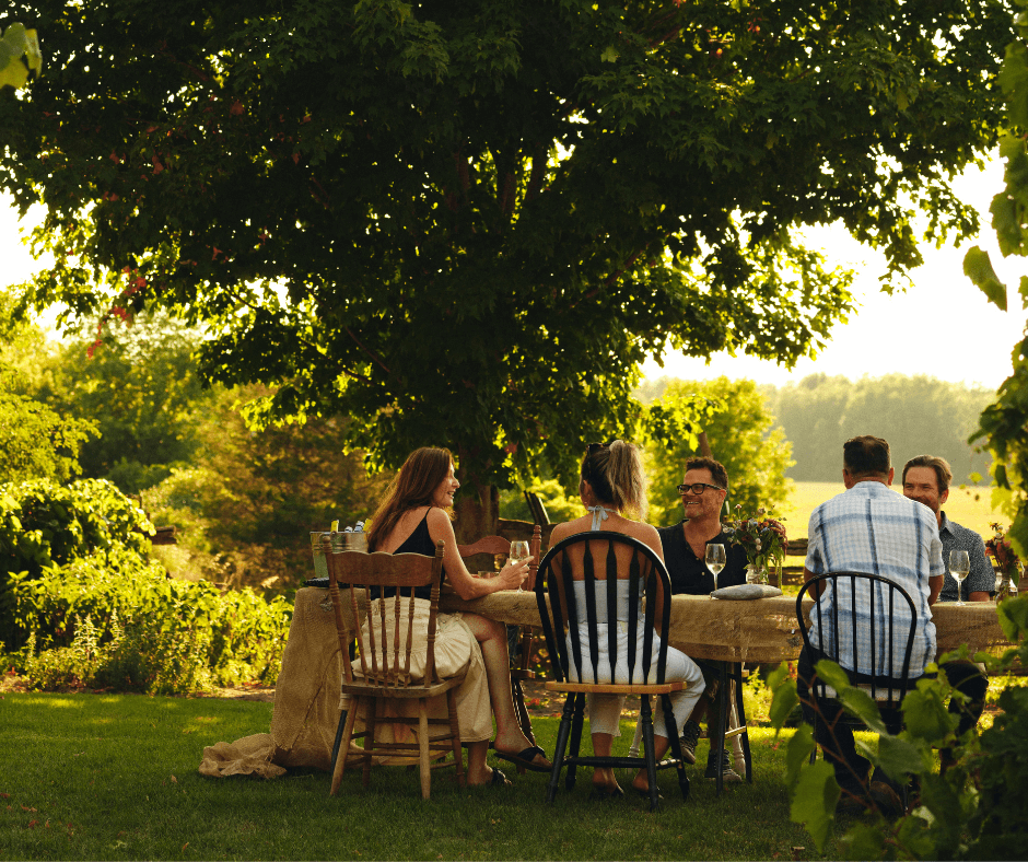 People sitting at table outside under tree