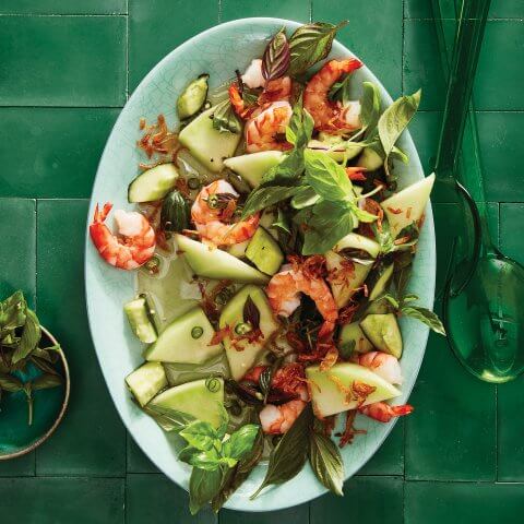 A platter of salad on a green tiled surface.