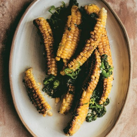 A platter with corn ribs on a tablecloth.