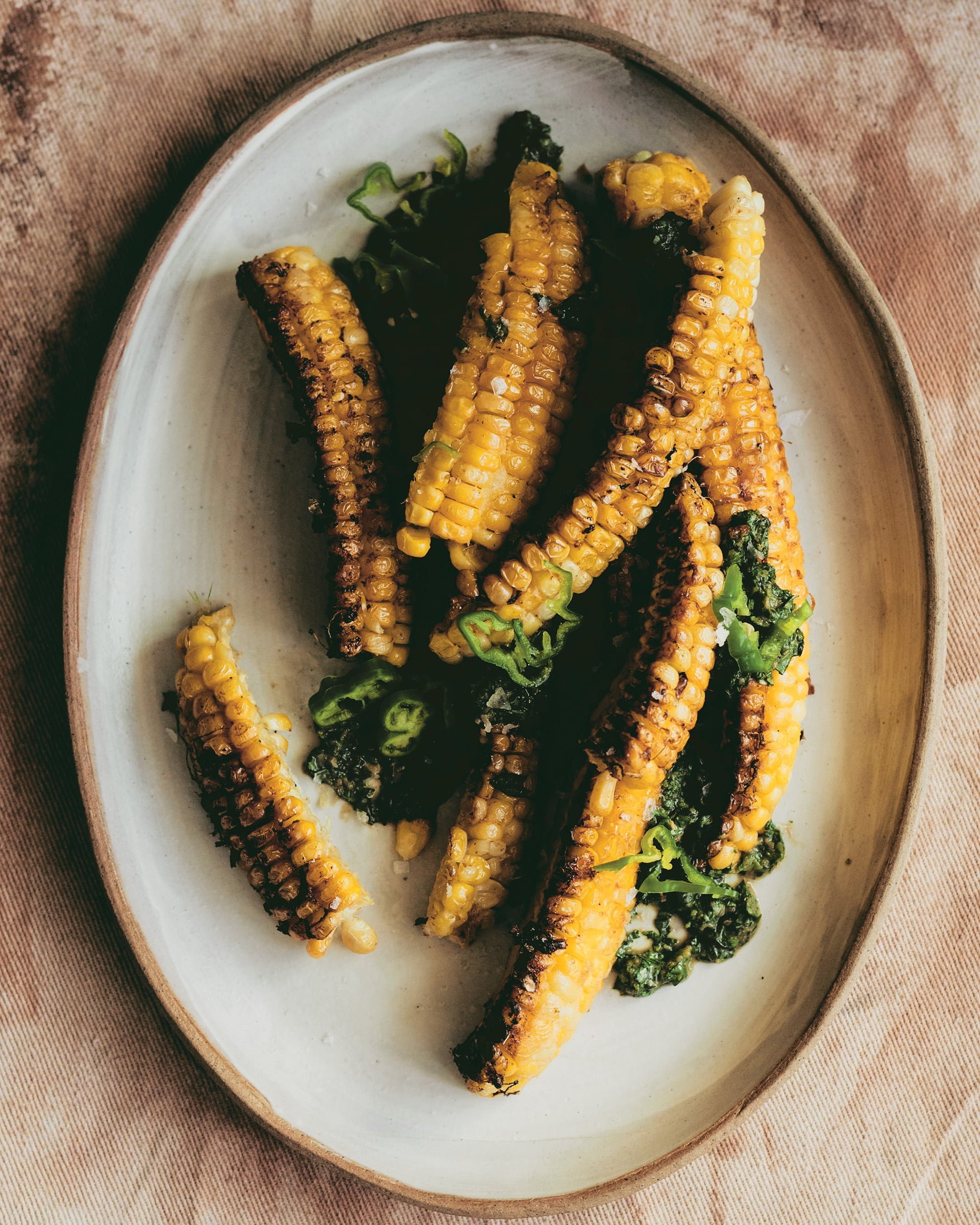 A platter with corn ribs on a tablecloth.