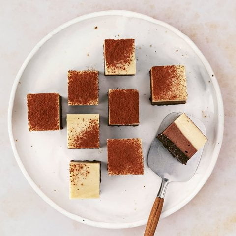 A plate with squares of tiramisu and a serving tool