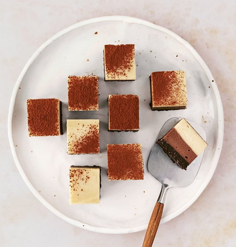 A plate with squares of tiramisu and a serving tool