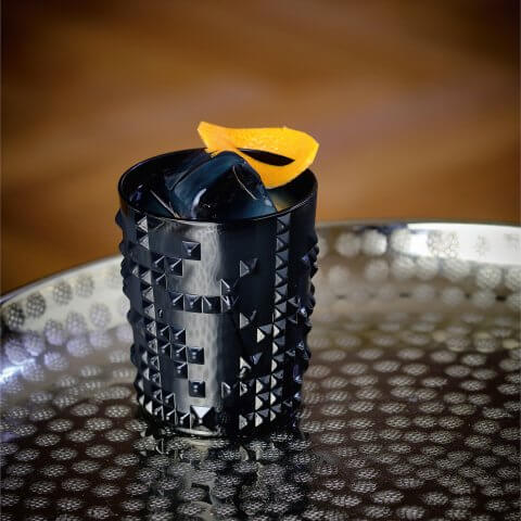 A black glass with orange peel garnish