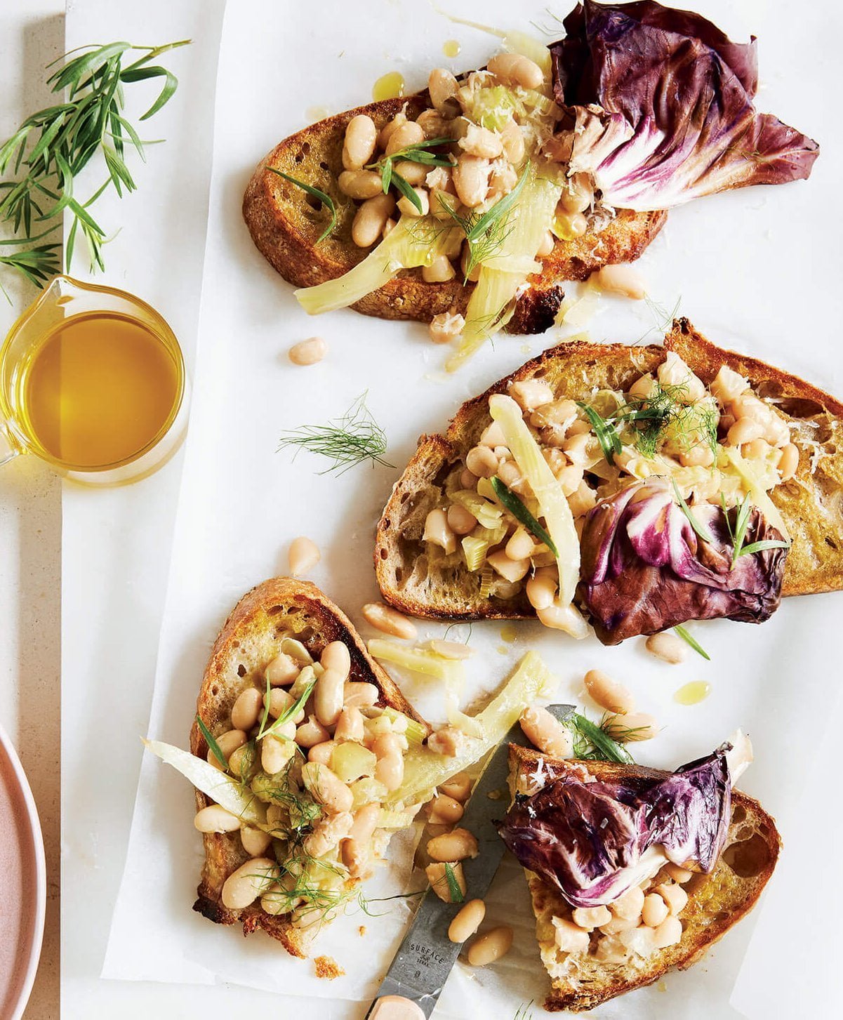 Slices of toast on a cutting board with beans and garnish