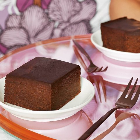Squares of brownies in front of patterned purple wallpaper with purple glasses