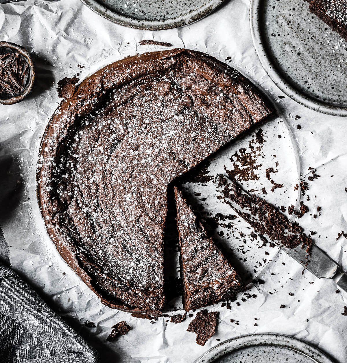 A sliced chocolate tart on a marble surface