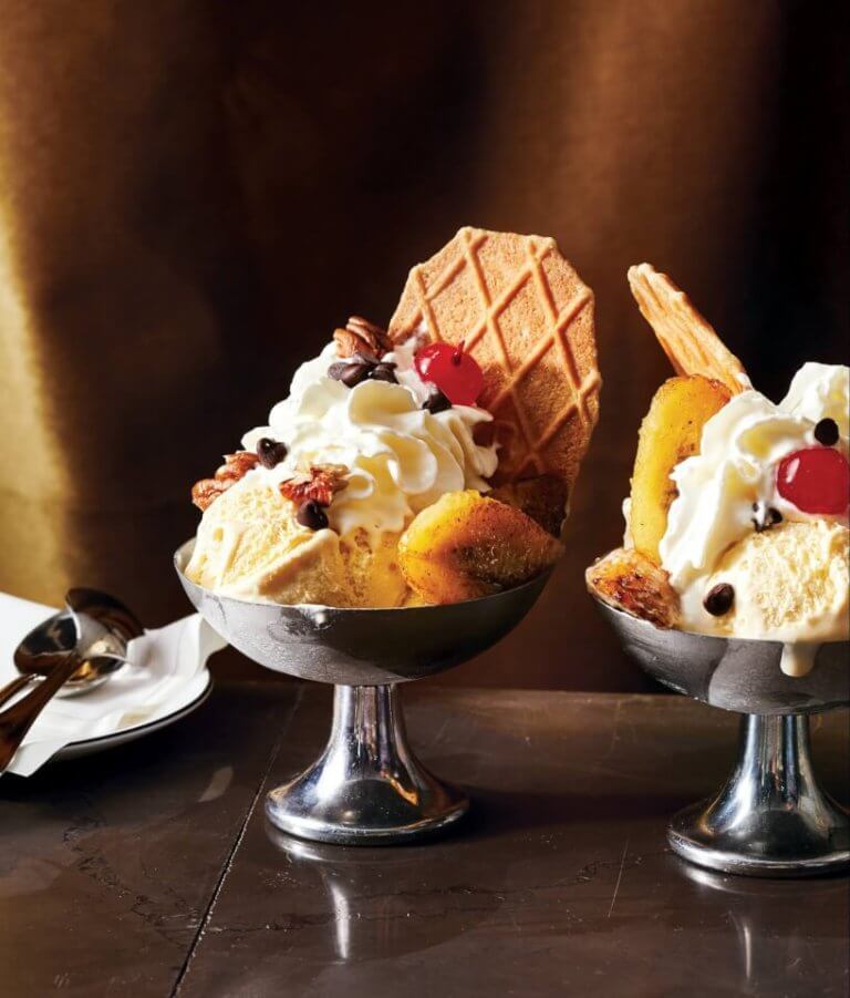 Silver bowls of ice cream with a wafer and sundae decorations