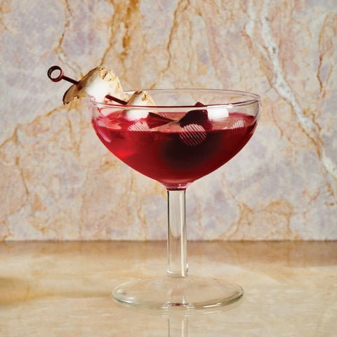 A dark red cocktail on a marble surface