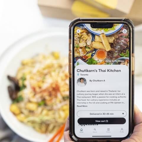 A phone with an order app held in front of food