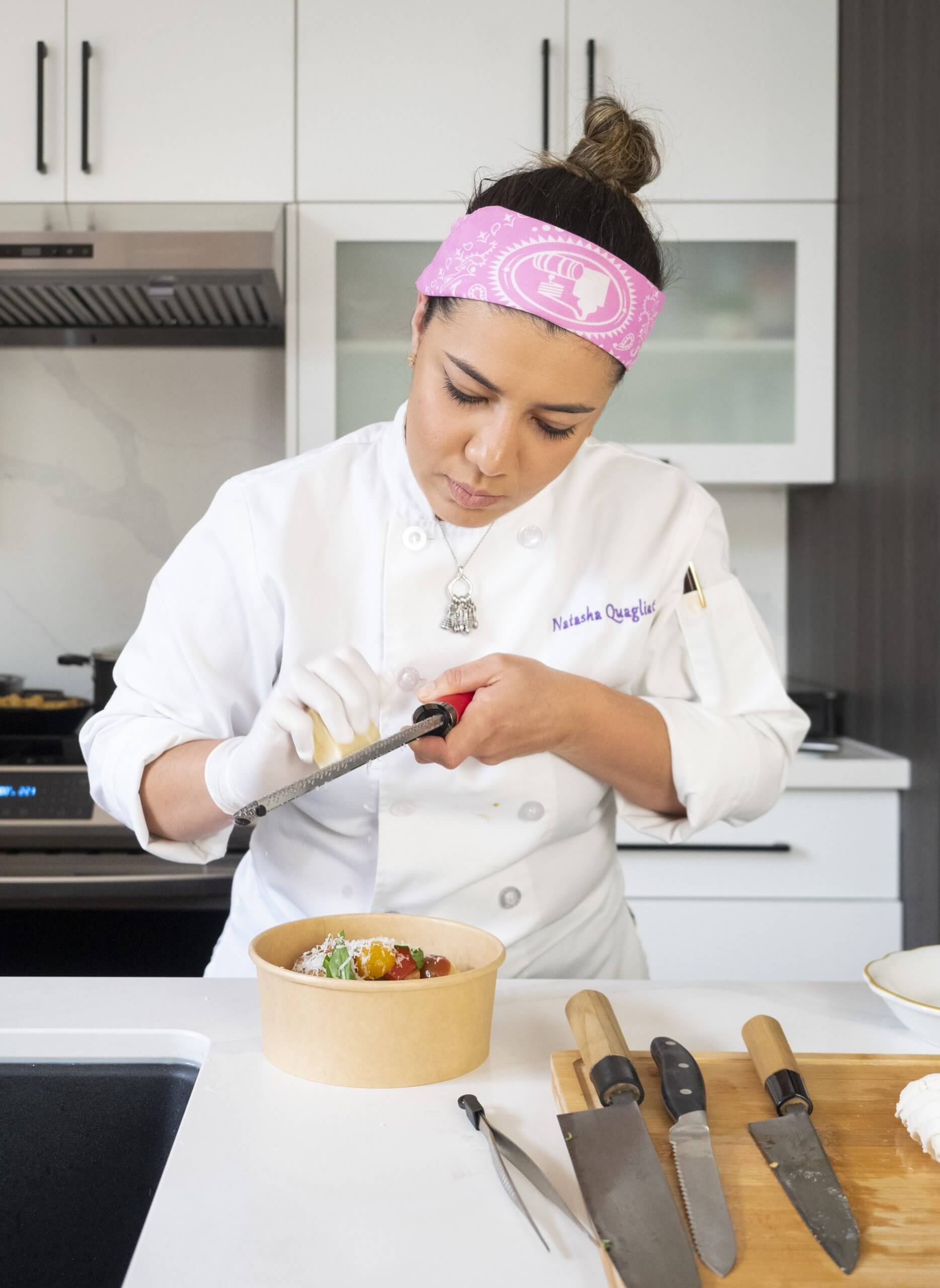 A woman with pink hairband cooks at a counter