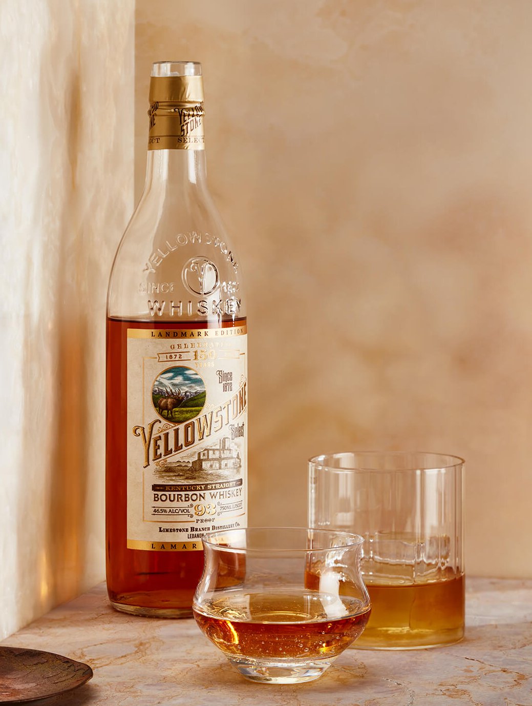 A bottle of Yellowstone bourbon and a glass with some poured