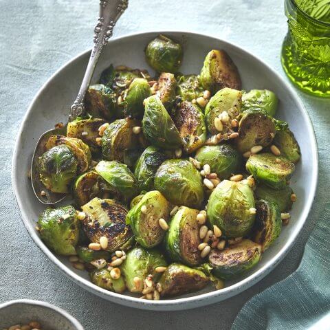 A bowl of Brussels sprouts with a spoon