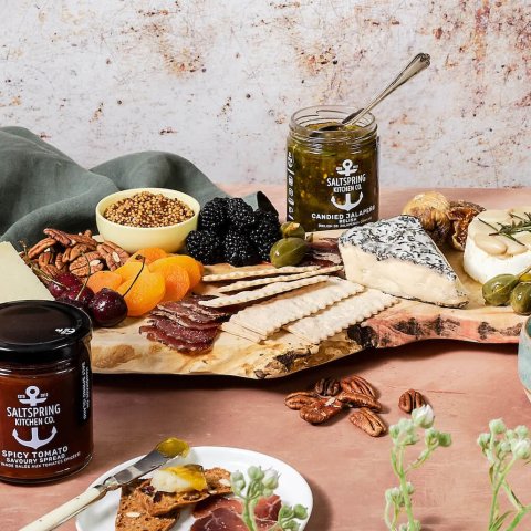 jars with jam and cheese on cutting board