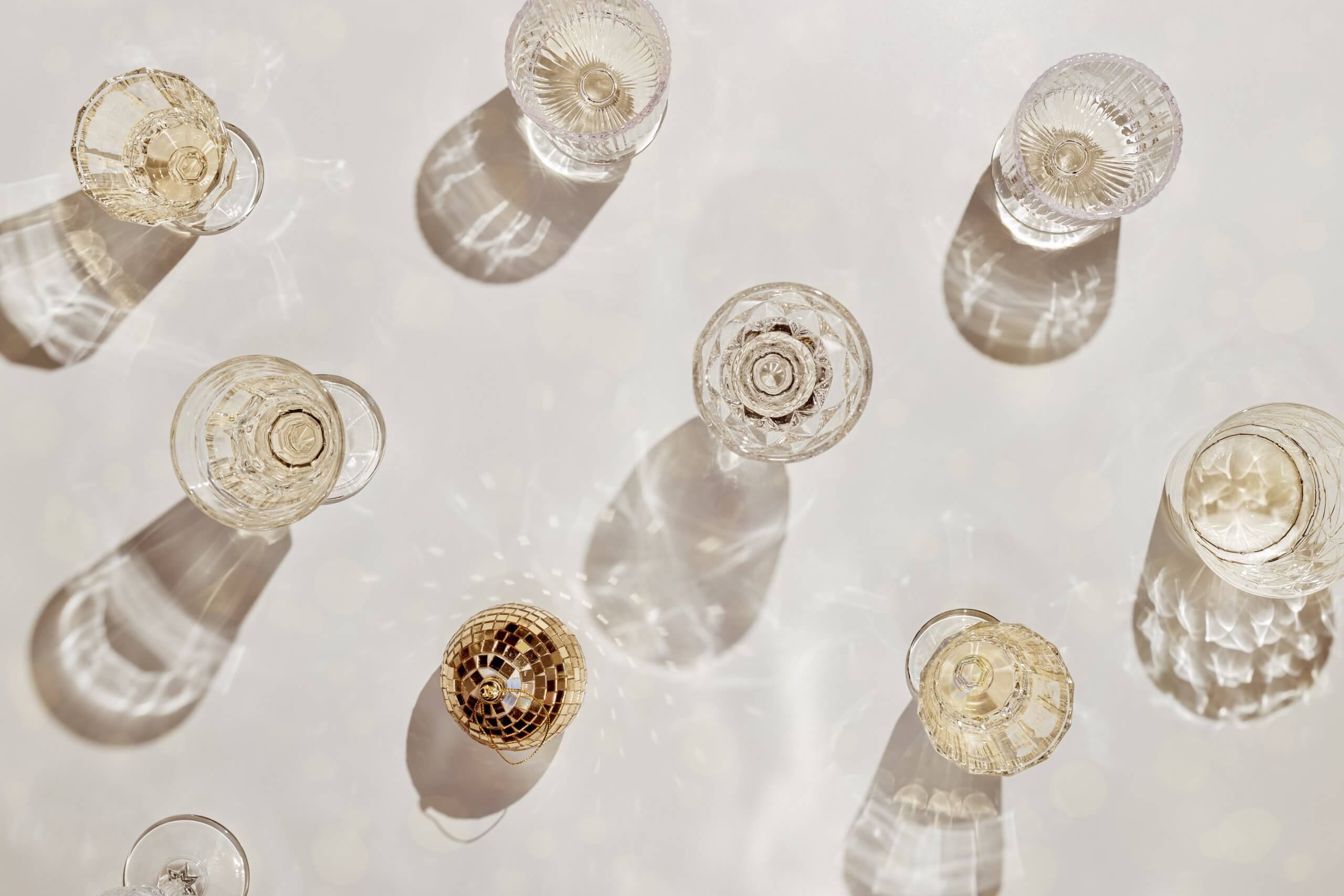 Glasses of champagne and a mini gold disco ball on a table