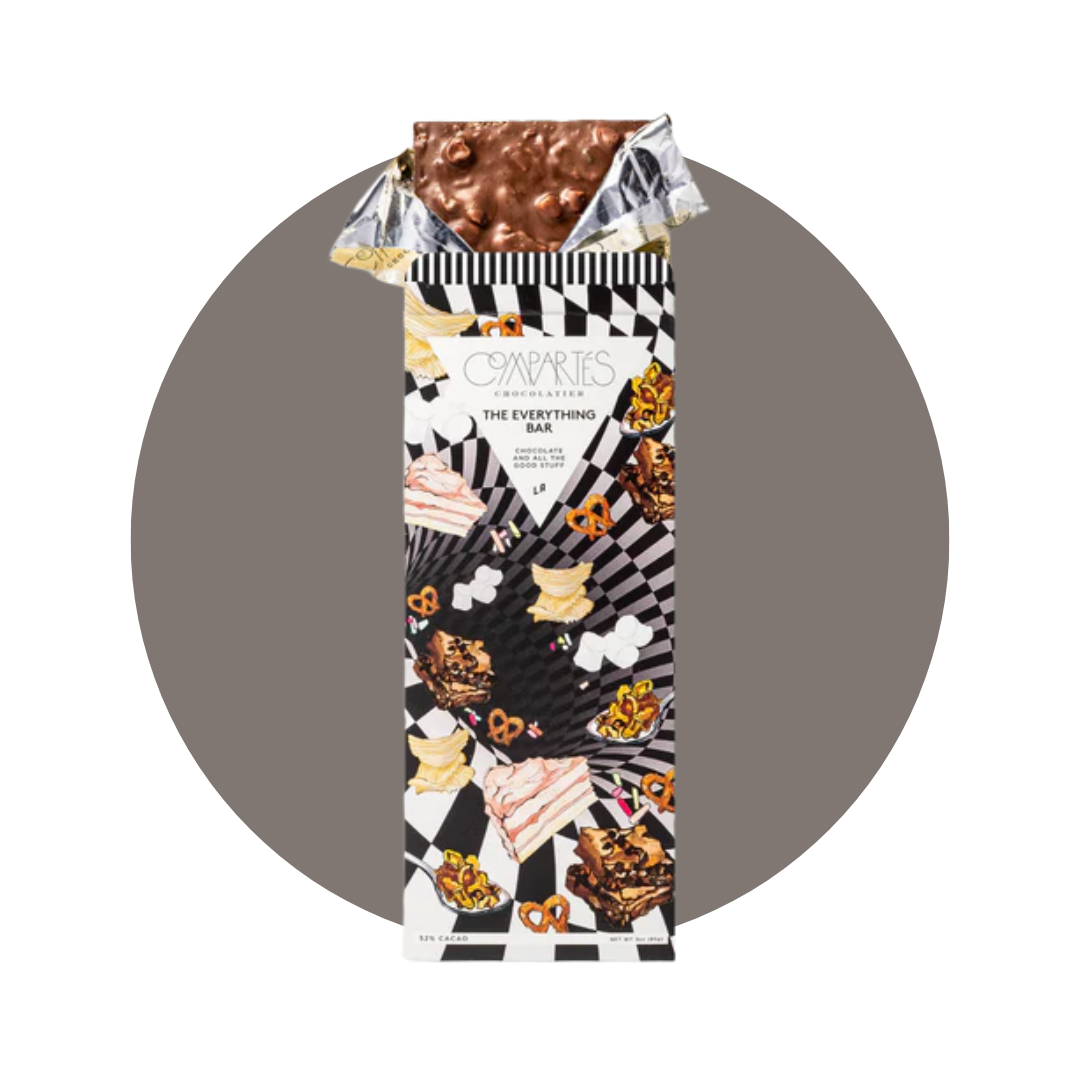 A chocolate bar coming out of foil wrapping and patterned packaging with a decorative gray circle background. 