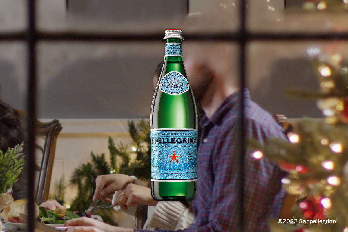 bottle of san pellegrino with people behind