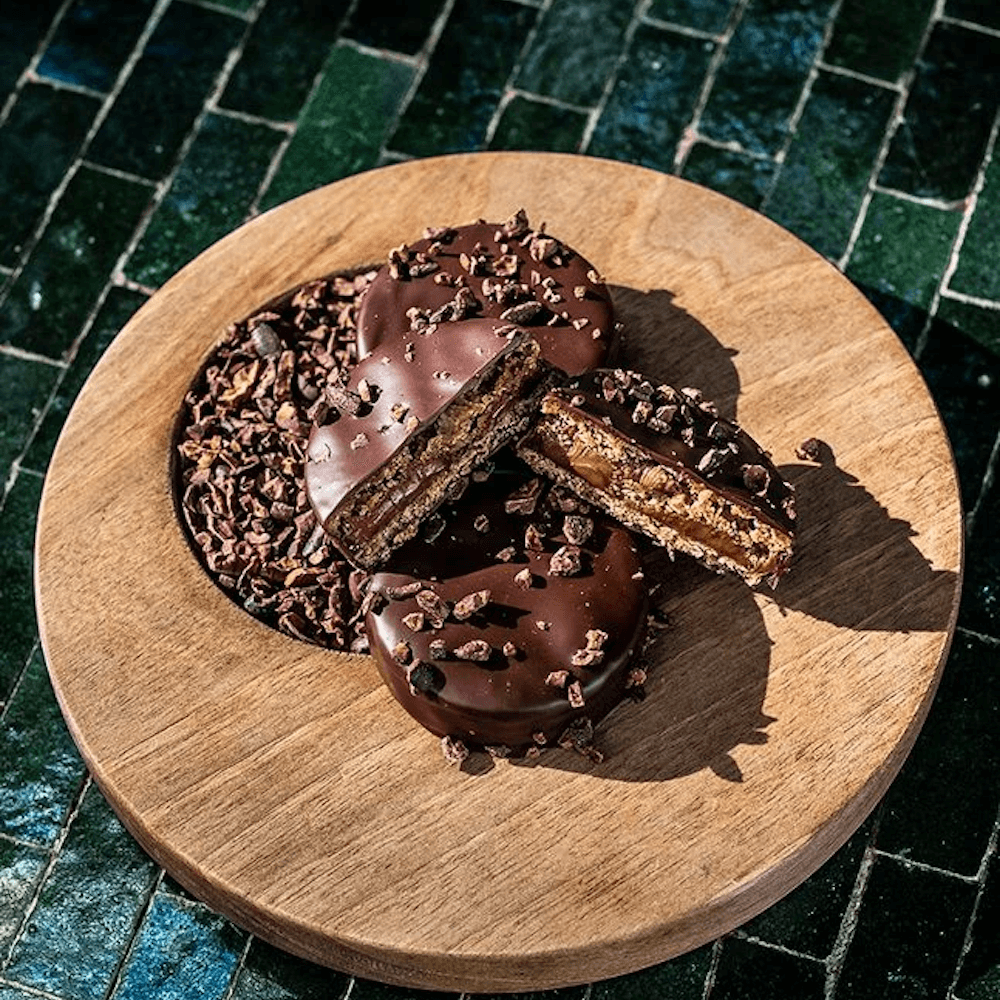 A cutting board with cookies on a green surface