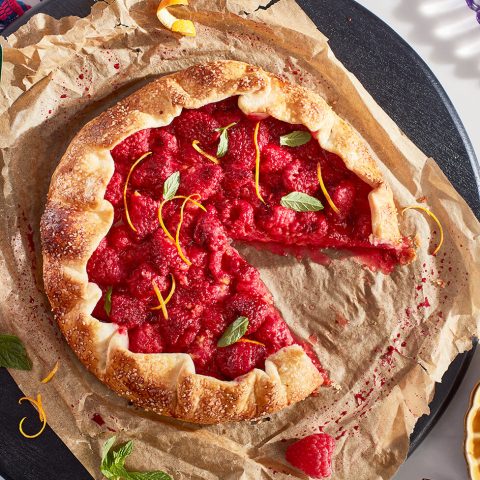 A raspberry dessert with one slice cut out.