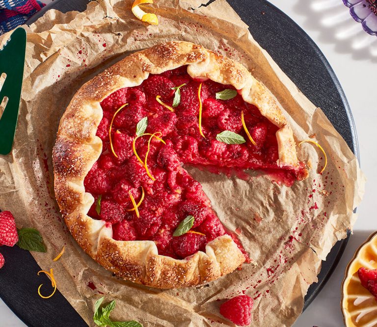 A raspberry dessert with one slice cut out.