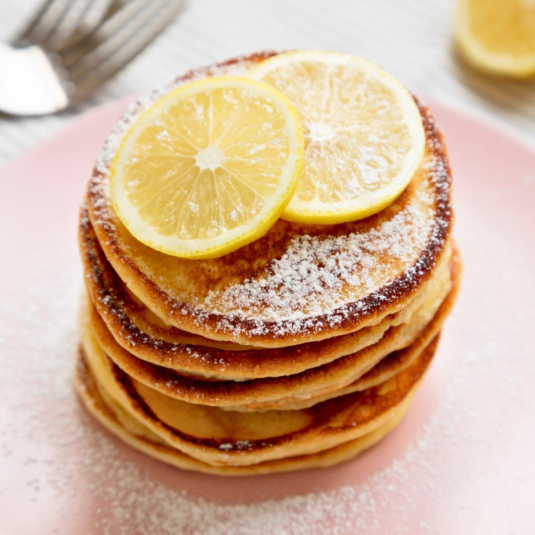 stack of lemon ricotta pancakes with lemons on top