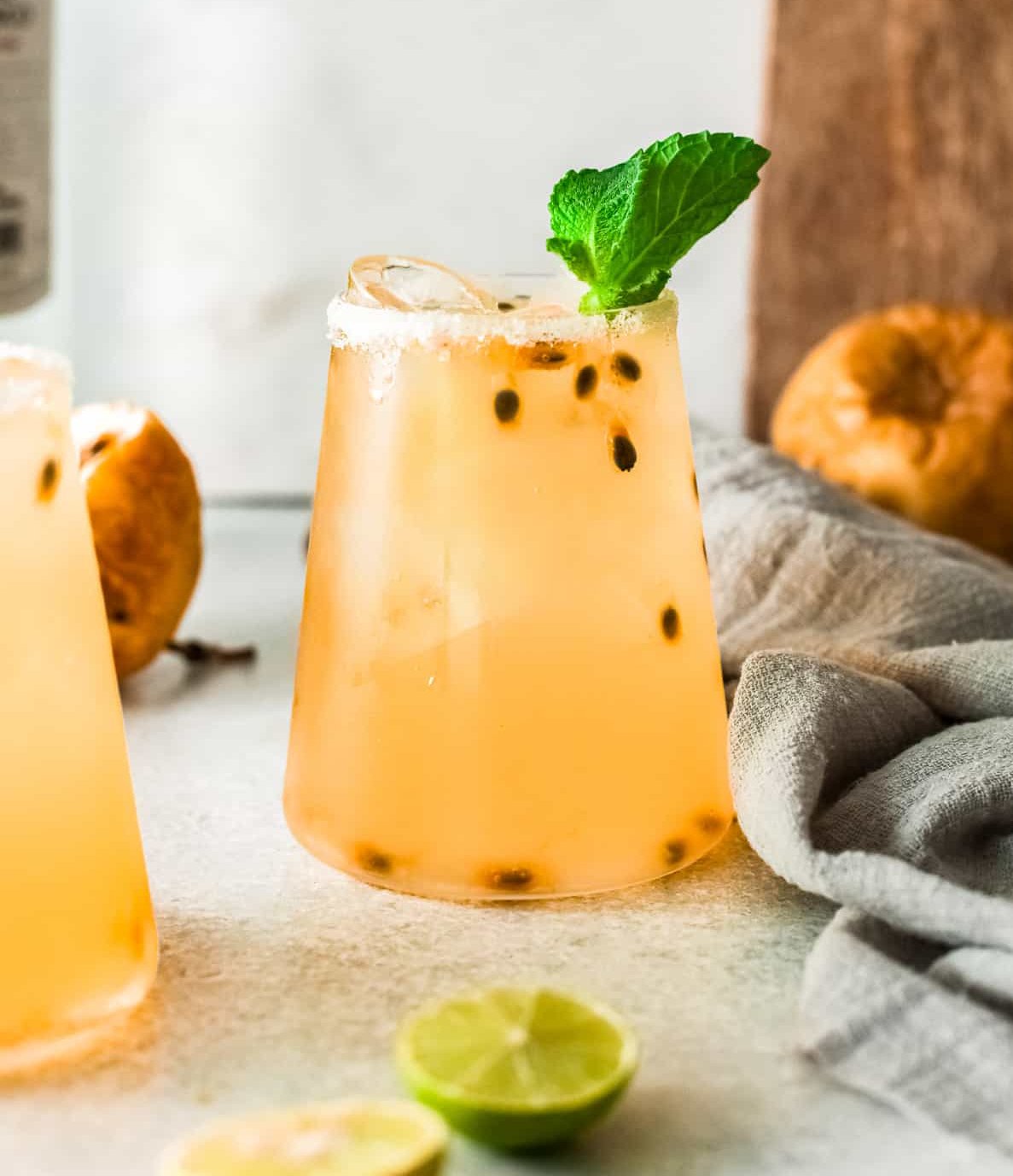 A light orange drink with passionfruit seeds.