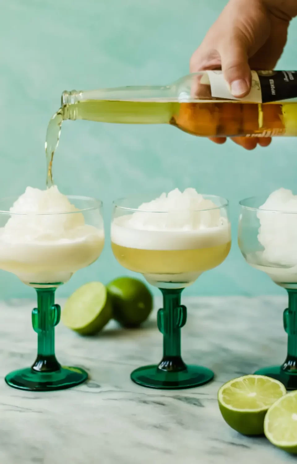 Beer is poured over a frozen cocktail in Margarita glasses.