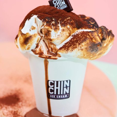 A picture of hot chocolate with ice cream in a paper cup.