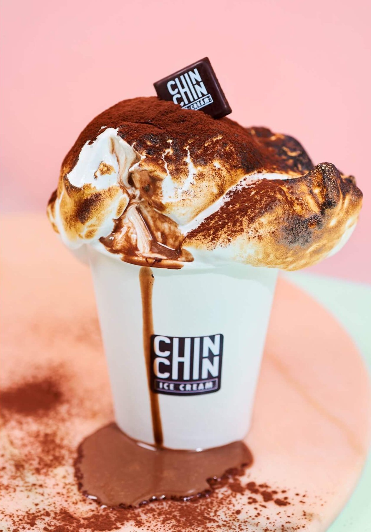 A picture of hot chocolate with ice cream in a paper cup.