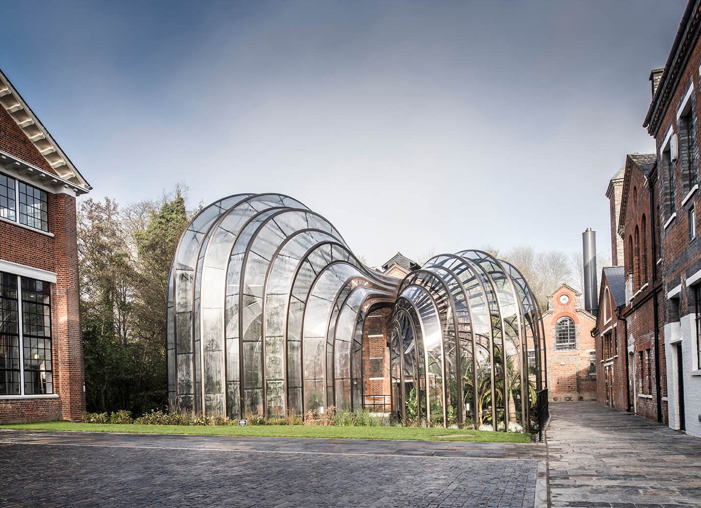 Landscape of two glass houses surrounded by brick buildings