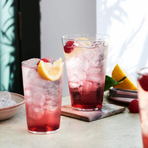 Two water glasses with cocktails on a countertop