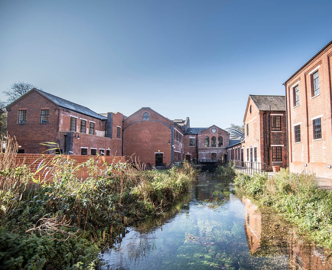 series of heritage brick buildings around the river test in Laverstoke, United Kingdom