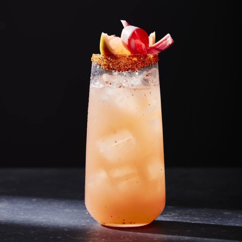 Glass of pink drink against black background