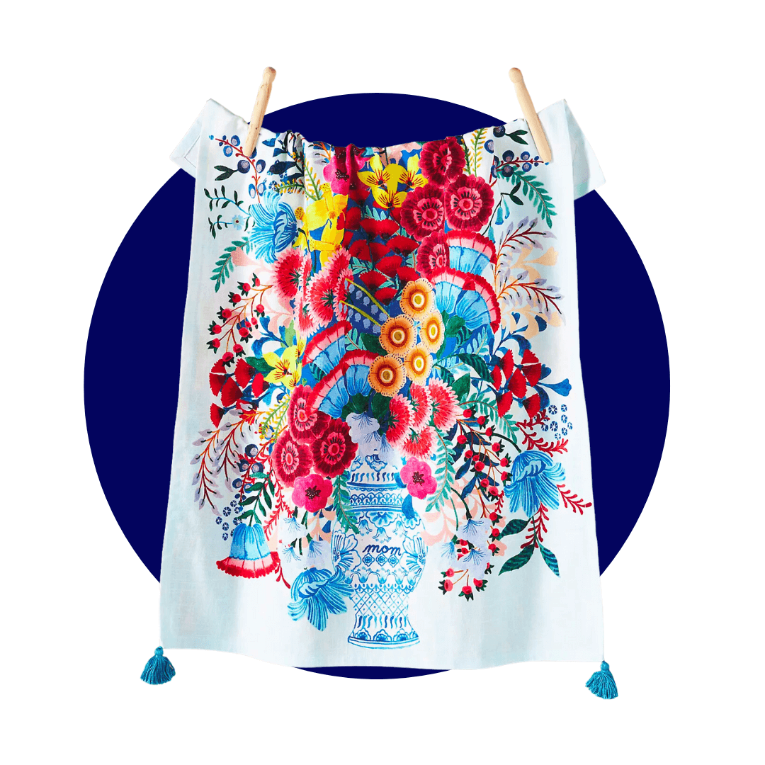 A brightly patterned dish towel hanging from clothespins on a dark blue circle graphic