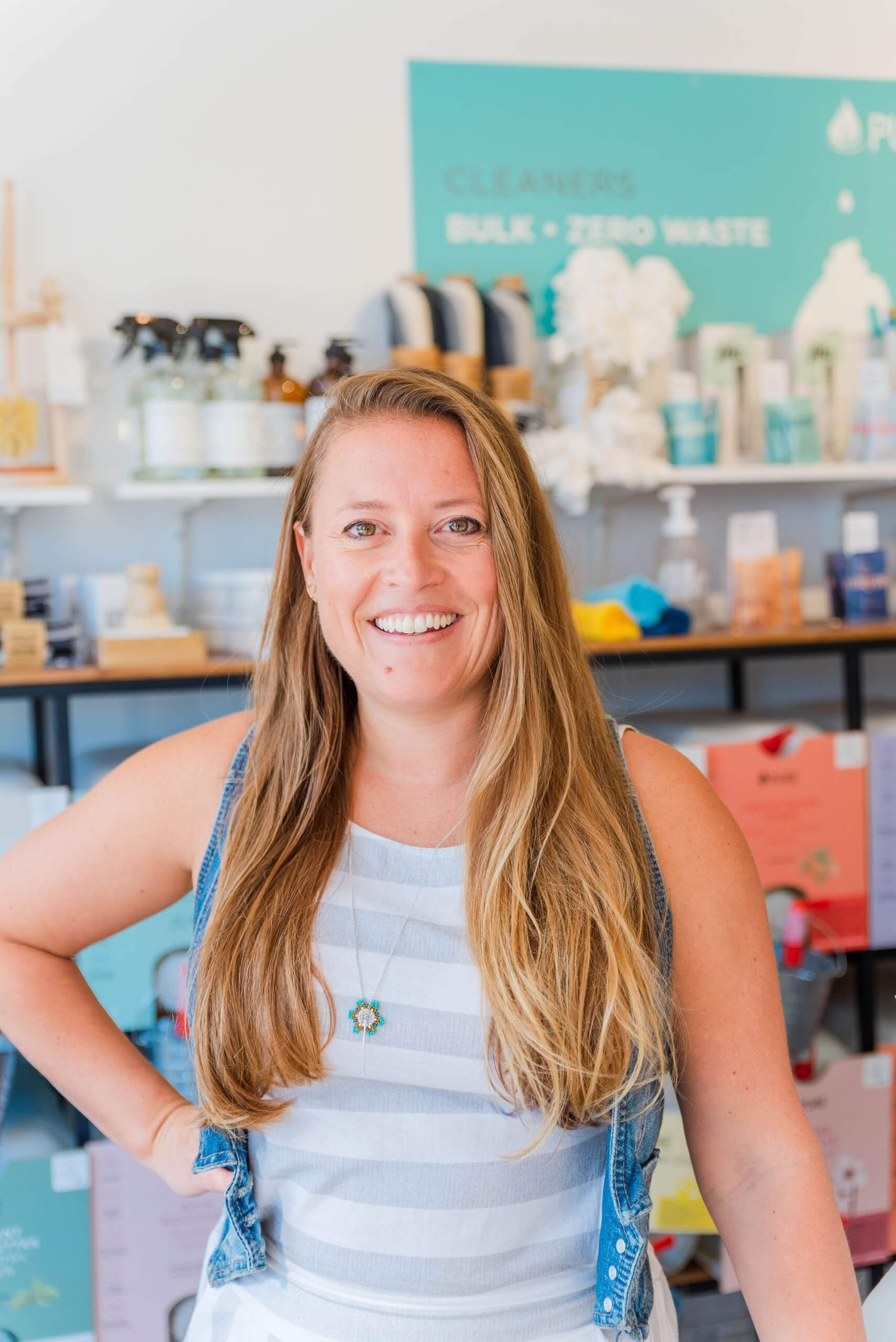 A woman smiling with store shelves in the background.