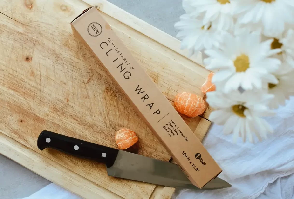 A brown box on a cutting board with flowers and clementines in the background.