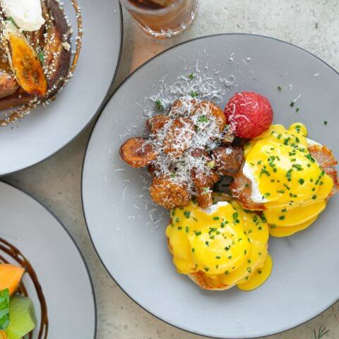 plate of egg benedicts on grey plate