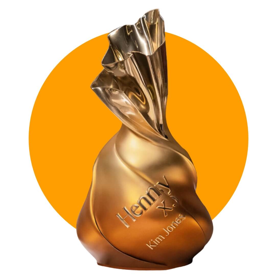 A sculptural Hennessy bottle on an orange circle graphic