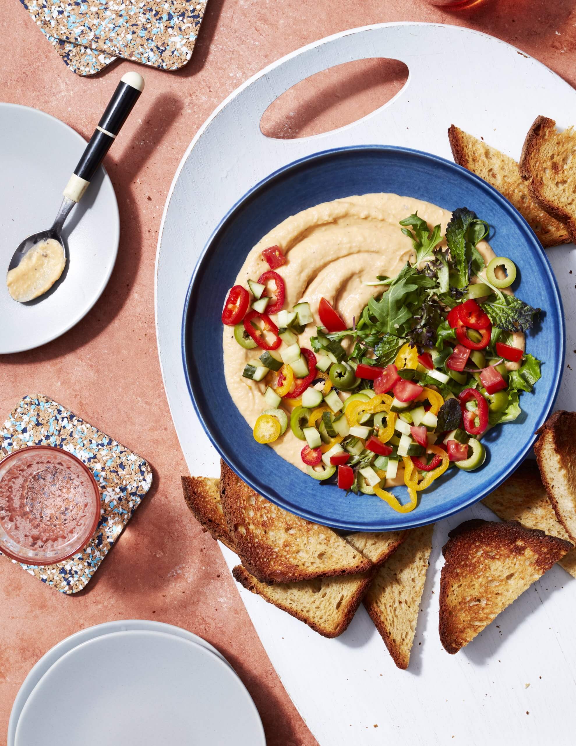 A blue bowl with dip and bread chips photographed from above.