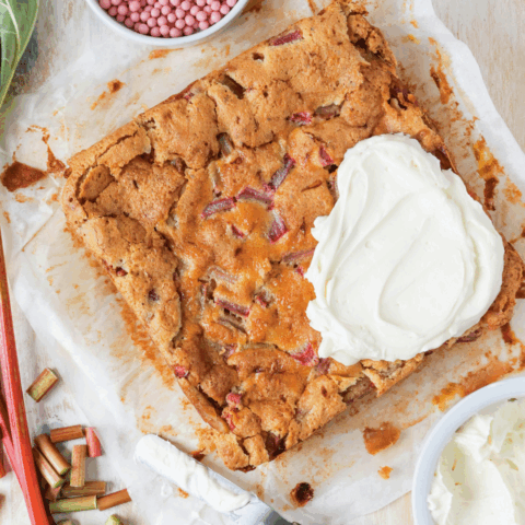 Recipe for rhubarb custard bars topped with a dollop of homemade cream cheese icing.