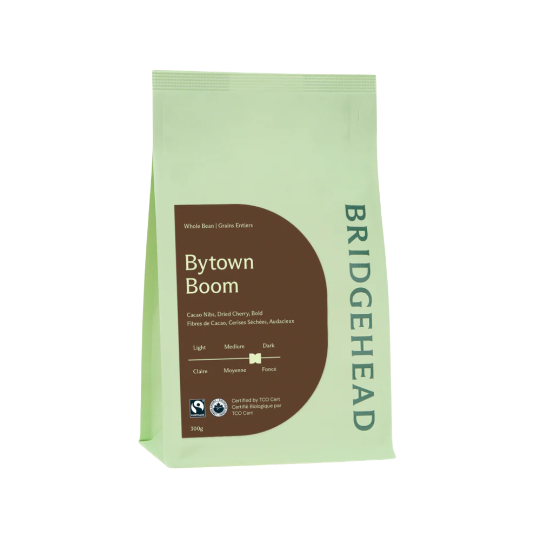 Green and brown bag of whole coffee beans.