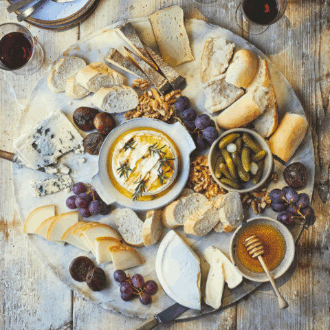 An overhead image of French cheeses and other French ingredients needed for a French Cheese Board