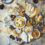 An overhead image of French cheeses and other French ingredients needed for a French Cheese Board