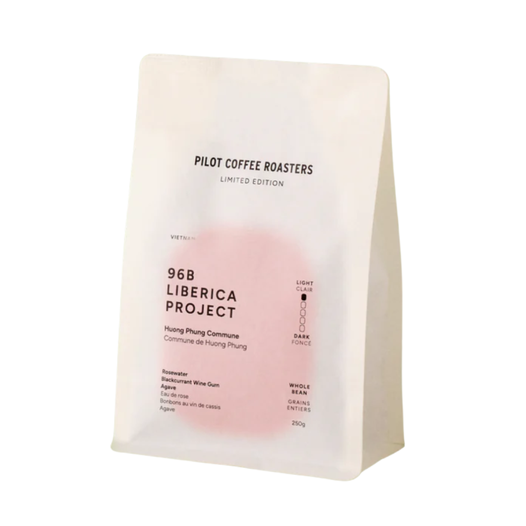 A white and pink bag of whole coffee beans.