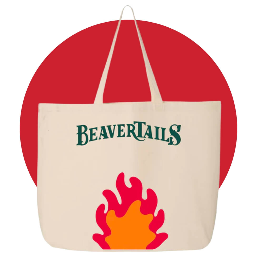 A tote bag with the word "BeaverTails" written in green and a campfire illustration on a red circle graphic
