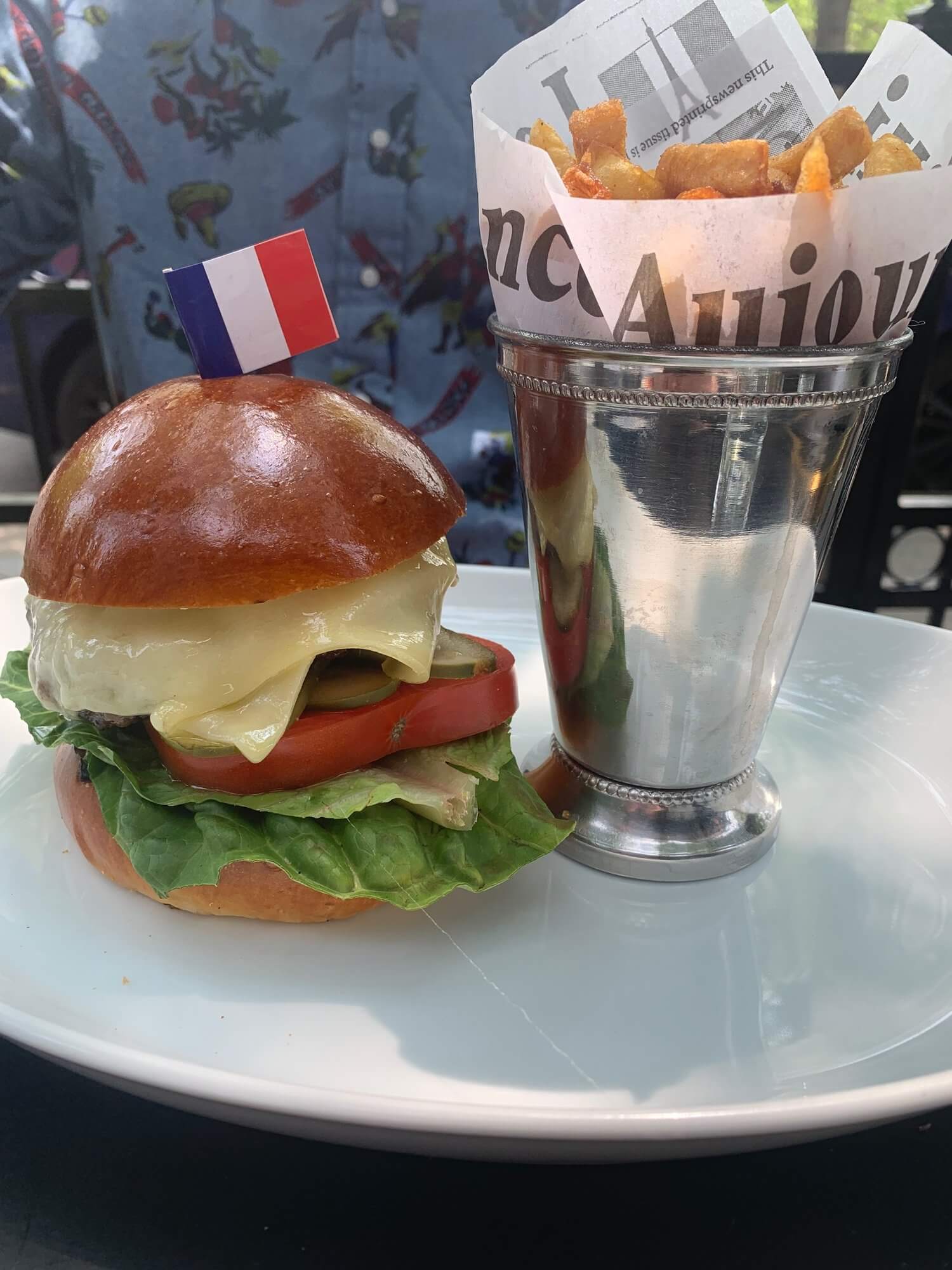 A hamburger and cone of fries on a white plate
