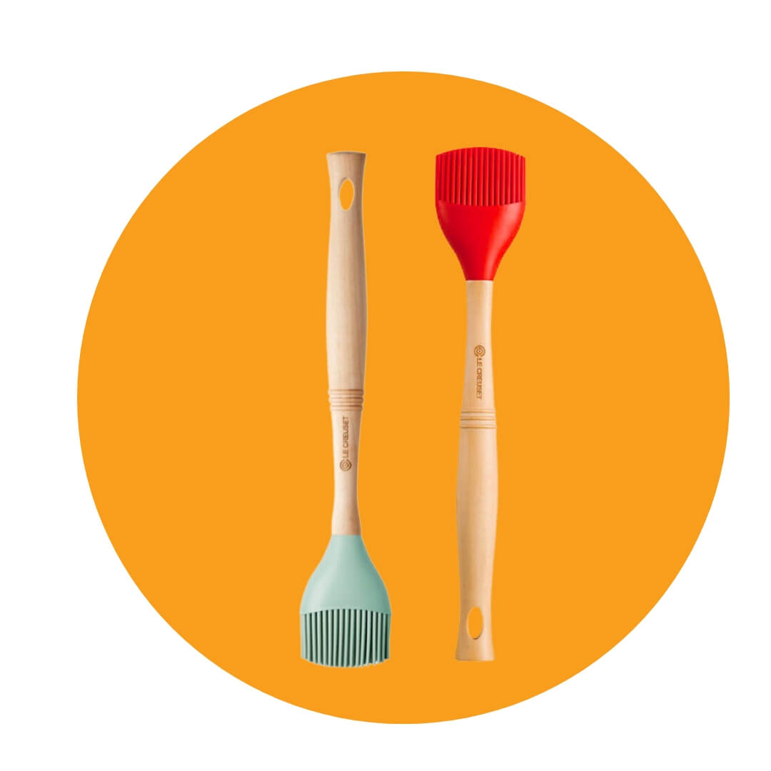 Two rubber brushes, one seafoam green and one bright red, on an orange circle graphic