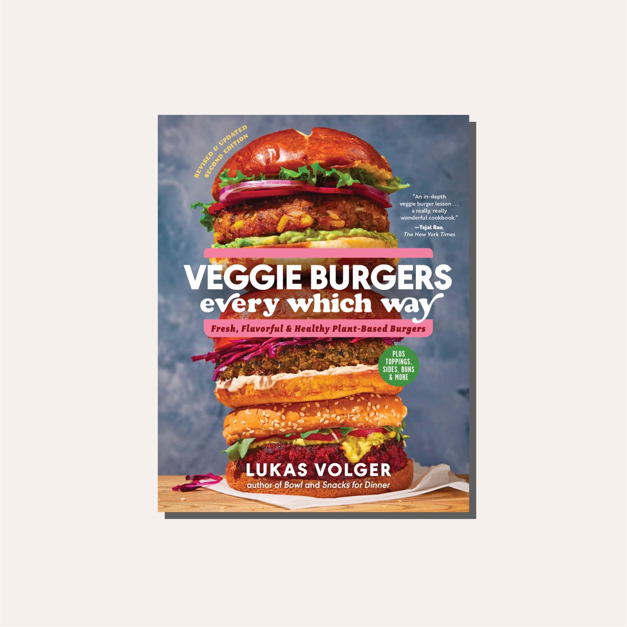 A cookbook cover with a stacked burger on it in a light tan frame